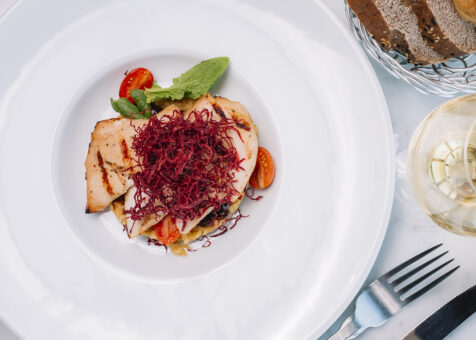 top view of grilled chicken fillet served with bulgur and vegetables and white wine