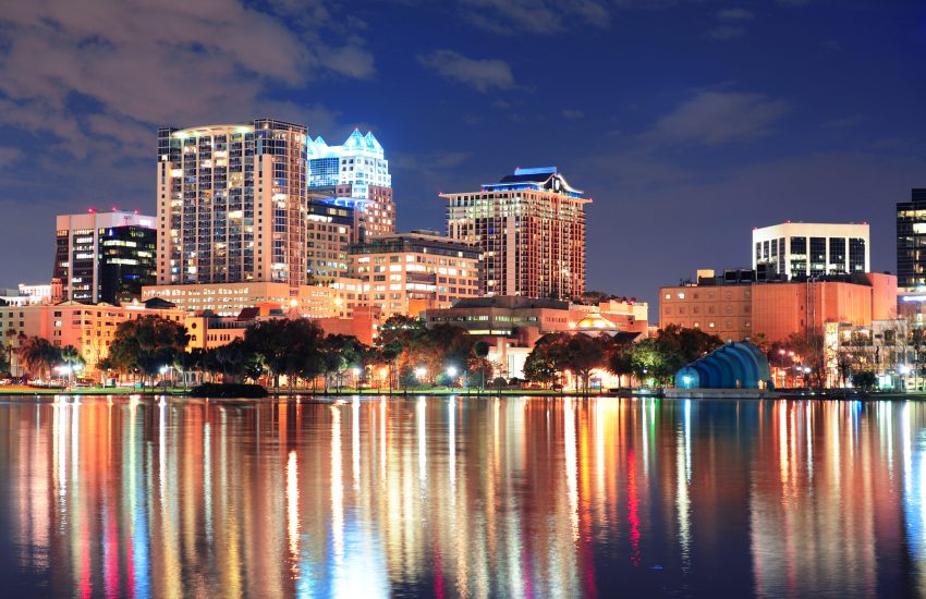 Orlando downtown skyline over Lake Eola at dusk with urban skyscrapers and lights.