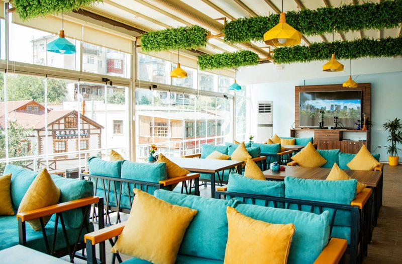 cafe terrace with turquoise sofas and yellow pillows