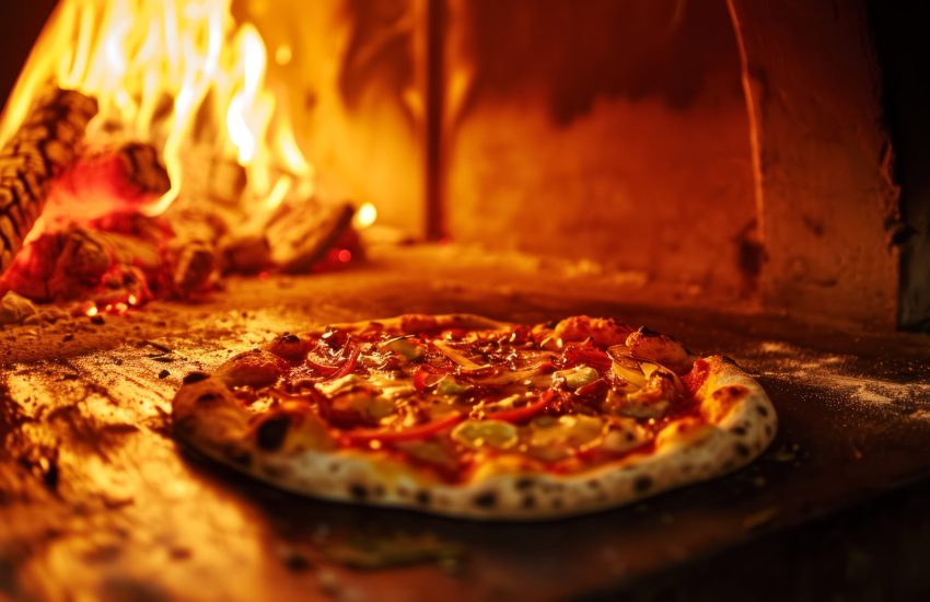 The pizza is cooked in a wood-burning oven. in an old cafe in the city center, the concept of a small local business, an idea for a banner or advertisement